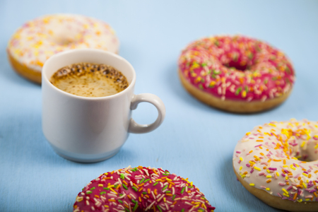 Donuts and a cup of coffee close-up on a blue wooden background.Tasty breakfast.の写真素材