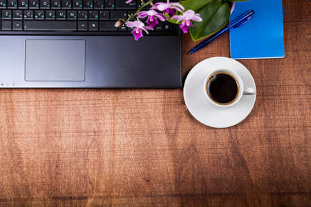 Workplace of  businessman with a laptop, top view. On the table are  cup of coffee,laptop and orhidの写真素材