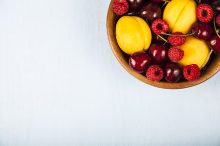 Ripe berries in a plate on a wooden table,top view.  Delicious and healthy dessert close-up, healthy diet.の写真素材