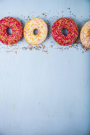 Multicolored donuts close-up on a wooden background. Delicious dessert.の写真素材