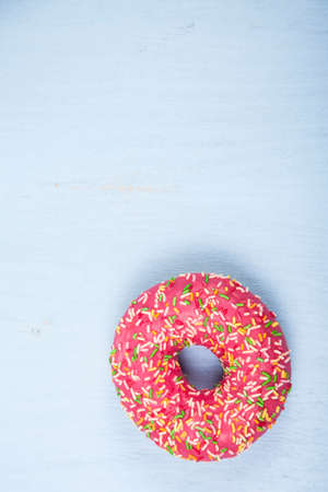 Pink donut close-up on a wooden background. Delicious dessert.の写真素材