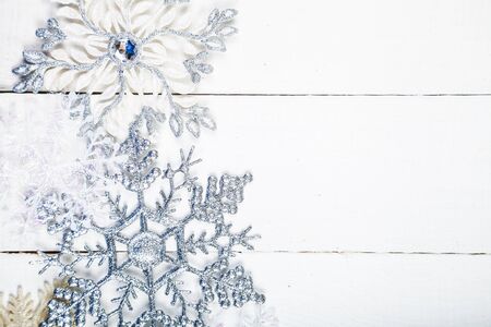 Silvery snowflakes on a white wooden background. Christmas decor.の写真素材