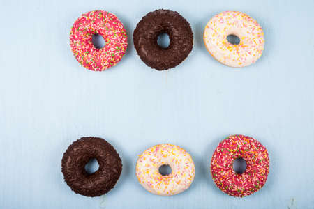 Multicolored donuts close-up on a wooden background. Delicious dessert.の写真素材
