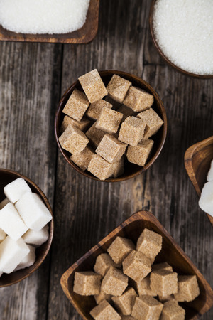 Six bowls of sugar  on an old wooden background, top viewの写真素材