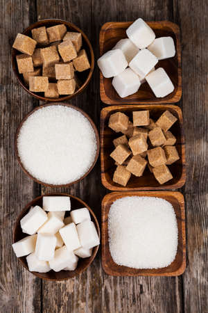 Six bowls of sugar  on an old wooden background, top viewの写真素材