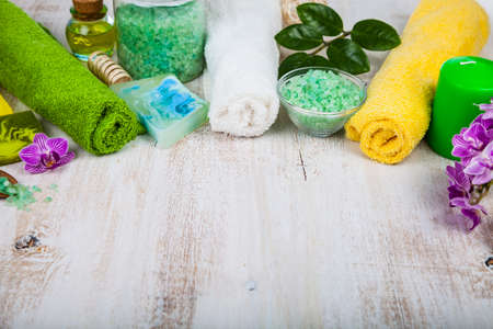 Spa treatments on an old  wooden table. Sea salt,towels, soap and orchid close-up.の写真素材