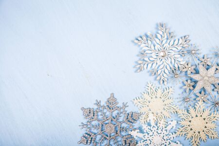 Silvery snowflakes on a blue wooden background. Christmas decor.の写真素材