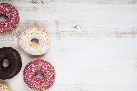 Multicolored donuts close-up on a wooden background. Delicious dessert.の写真素材