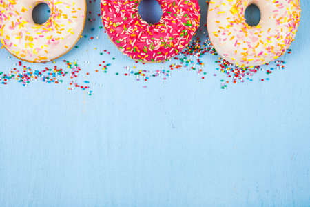 Multicolored donuts close-up on a wooden background. Delicious dessert.の写真素材