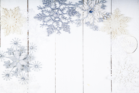 Silvery snowflakes on a white wooden background. Christmas decor.の写真素材