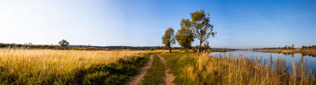 Beautiful landscape. Road near the lake early in the morning. Panorama.の写真素材