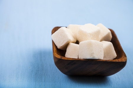 Sugar in a wooden bowl  on a blue wooden background.の写真素材