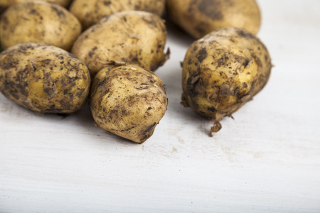 Raw potatoes  on a wooden tableの写真素材