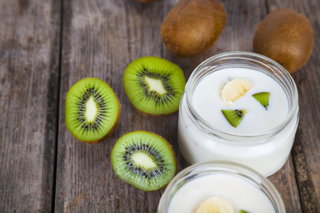Yogurt with kiwi on a wooden background. Tasty breakfast. Healthy eating.の写真素材
