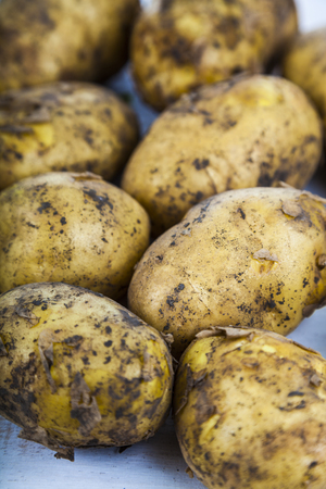 Raw potatoes on a wooden tableの写真素材