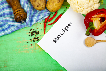 Culinary recipe, towel, spoon and various vegetables on a green wooden table. Cooking. Menu.の写真素材