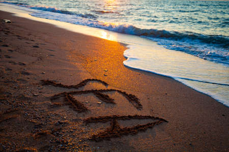 Beautiful sea at sunset. Word "sea" in the sand. Seascape.の写真素材