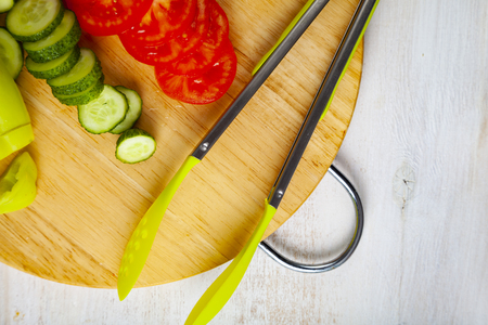 Vegetables for salad and cutting board on the table. Preparation of dinner.の写真素材