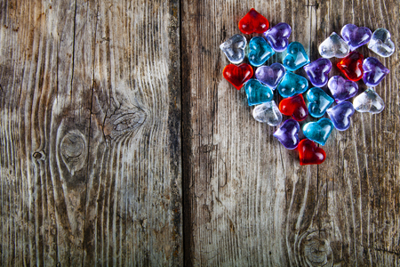 Heart of multi-colored glass hearts  on an old wooden background. Romantic background.の写真素材