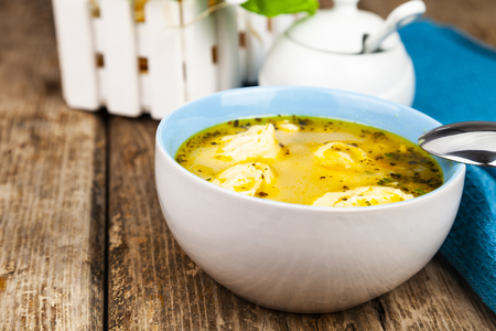 Chicken soup with dumplings on a wooden tableの写真素材