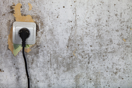 Socket on a gray wall. Repair in the house.