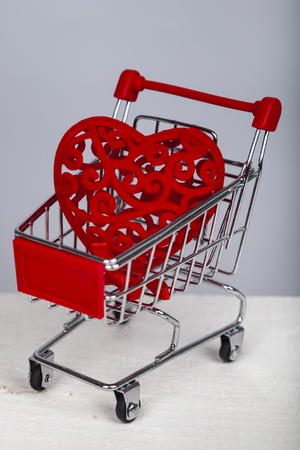 Heart in the shopping cart on a gray background. Shopping for the holiday.の写真素材