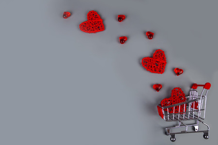 Hearts and shopping cart on a grey background. Shopping for the holiday.の写真素材