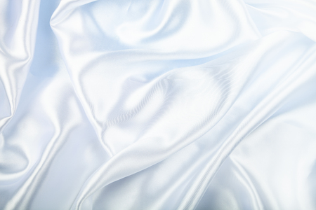 White silk fabric with folds. Beautiful background.の写真素材