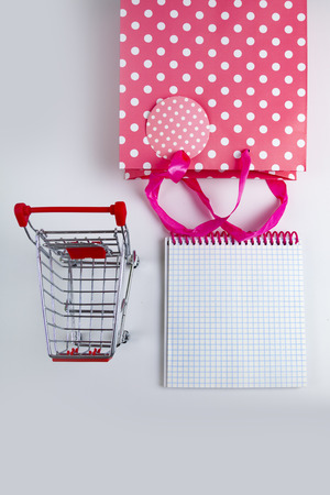 Pink shopping bag, lavender, notepad and shopping cart, top view.の写真素材