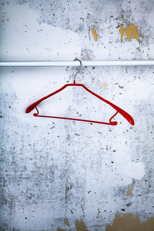 Red hanger on a gray wall background.の写真素材