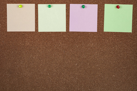Corkboard with notes. Colored paper on corkboard.の写真素材