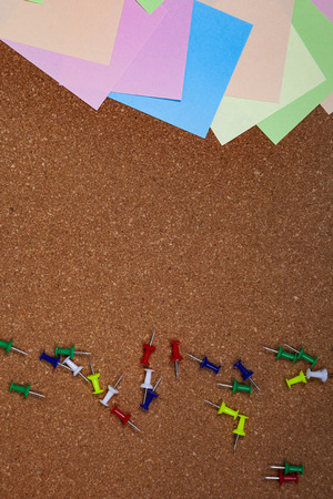 Corkboard with notes. Colored paper on corkboard.の写真素材