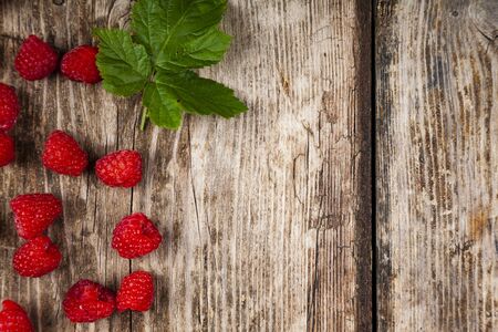 Ripe raspberry on an old wooden table. Delicious berries.