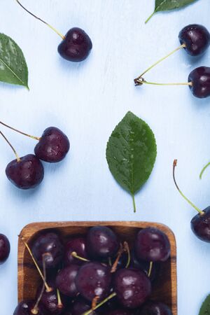 Ripe sweet cherry in a square bow on a wooden table, top view. Delicious berries.の写真素材
