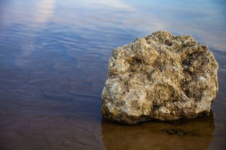 Beautiful landscape with a calm river. Stone in the river