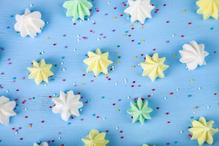 Meringue on a blue  wooden background, top view. Delicious dessert. Colorful handmade meringue.の写真素材