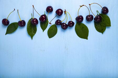 Ripe sweet cherry on a blue wooden table. Delicious berries.Place for your text.の写真素材