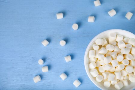 Marshmallow in a bowl on a blue  wooden background. Delicious dessert. Colorful handmade meringue.の写真素材