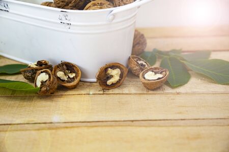 Walnuts and leaves on a wooden table.
