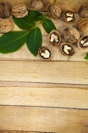 Walnuts and leaves on a wooden table.の写真素材