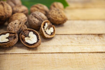 Walnuts and leaves on a wooden table.