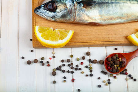 Raw mackerel on a cutting board with spices. Cooking fish.