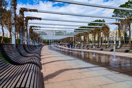 City Park "Krasnodar" or Galitsky Park. Fountain and benches for rest in the park around the football stadium "Krasnodar". Landscaping. Krasnodar, Russia - April 24, 2021のeditorial素材