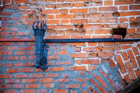 Metal torch stand on an old brick wall. Fragment of the Kolomna Kremlin. Kolomna, Russia.の写真素材