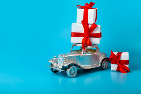 Silver car with gifts on a blue background. Buying a car.