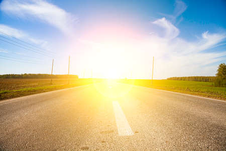 Road and bright sun. Summer landscape. Path to a brighter future.の写真素材