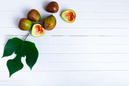Figs with leaves on a light wooden background.の写真素材