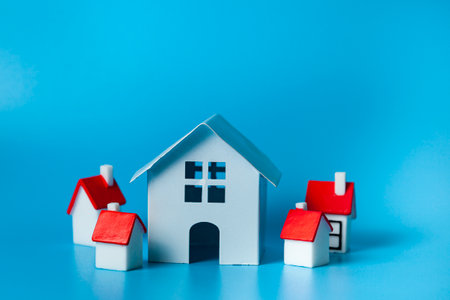 House surrounded by small houses on a blue background. Real estate purchase concept.の写真素材