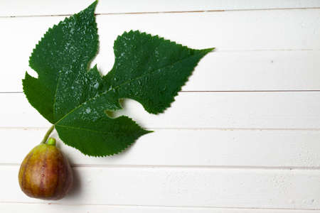Figs with leaves on a light wooden background.の写真素材