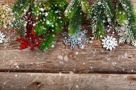 Christmas tree branches and snowflakes on an old wooden background. Christmas decor. Place for your text.の写真素材